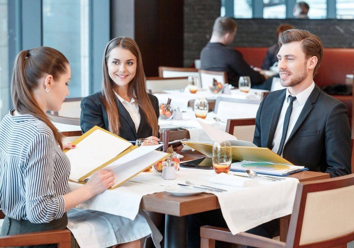 A group of people sitting at tables with papers.